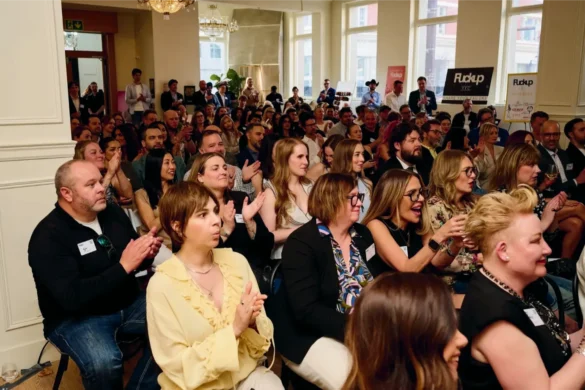 Audience applauding at a Fuckup Nights Yyc event with speakers on stage