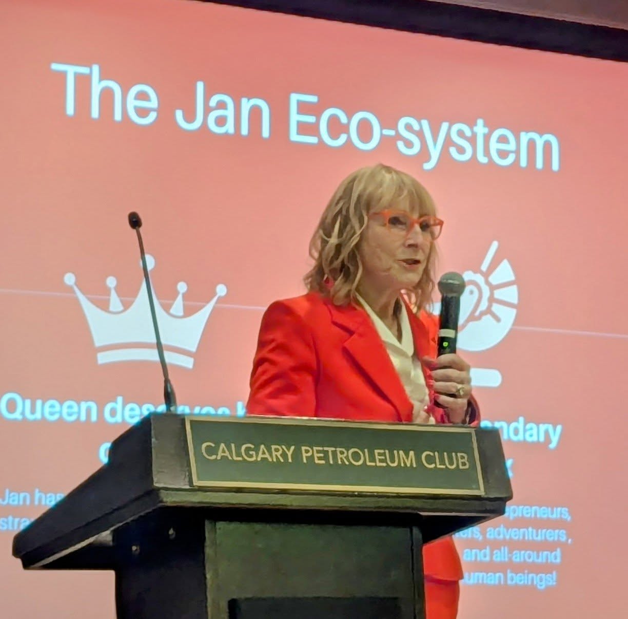 Jan Eden speaking at a podium at the Calgary Petroleum Club