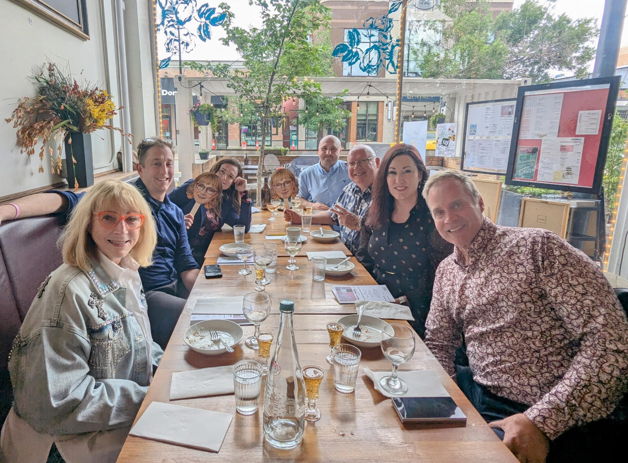Jan Eden seated at a restaurant table with the team who conducted the Eden Celebration
