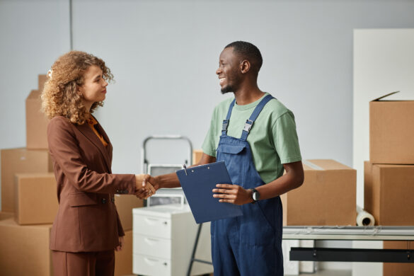 Businesswoman shaking hands with a worker holding a clipboard
