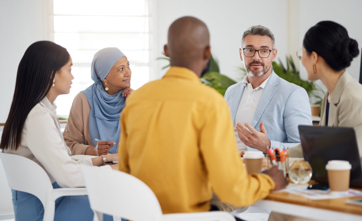 Diverse group of professionals in discussion around a meeting table