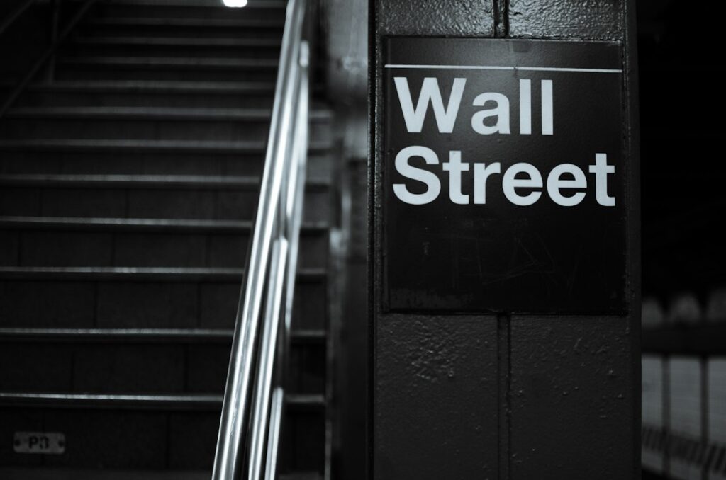 a black and white photo of a wall street sign