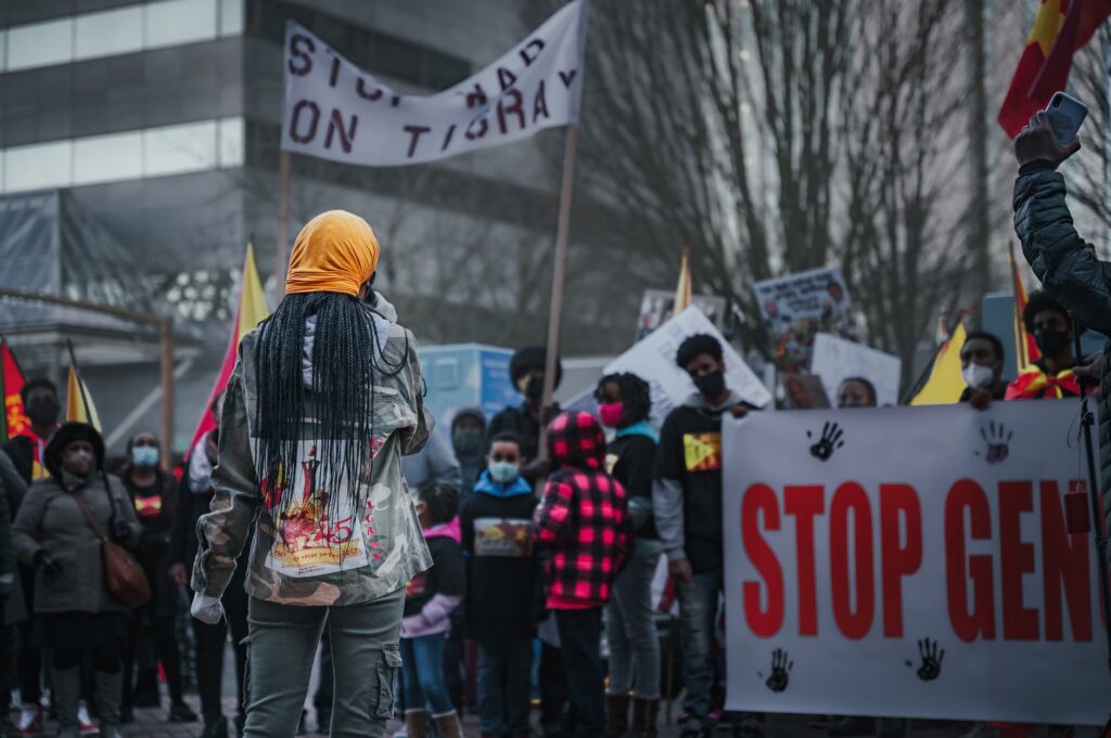 Group of African American people wearing medical masks standing with banners while participating in demonstratio...