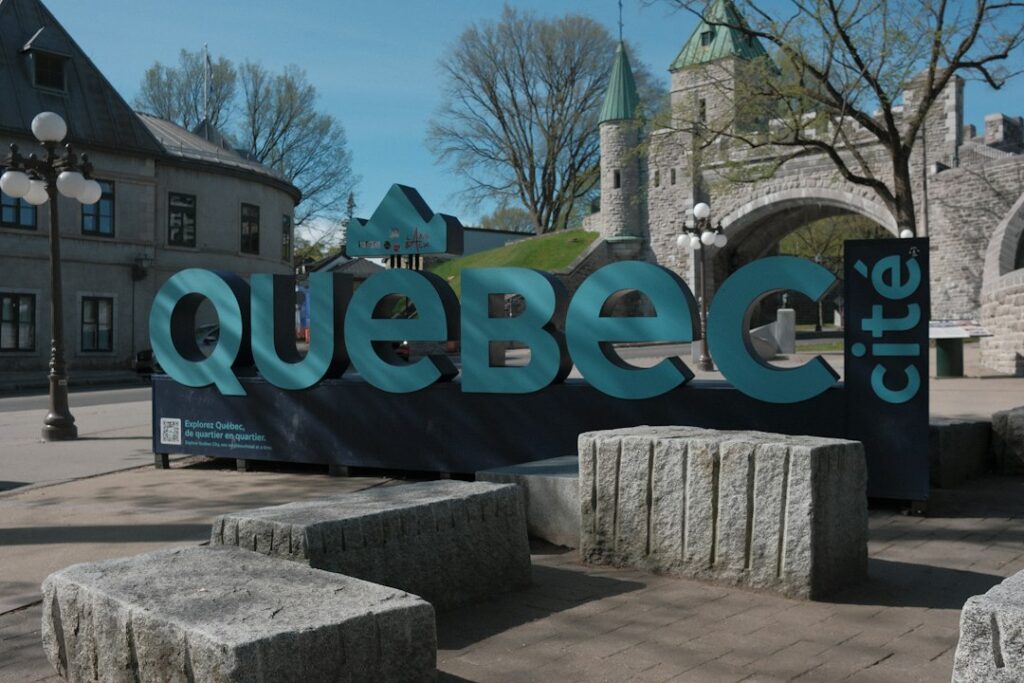 Large "québec cité" sign with historic buildings and stone blocks