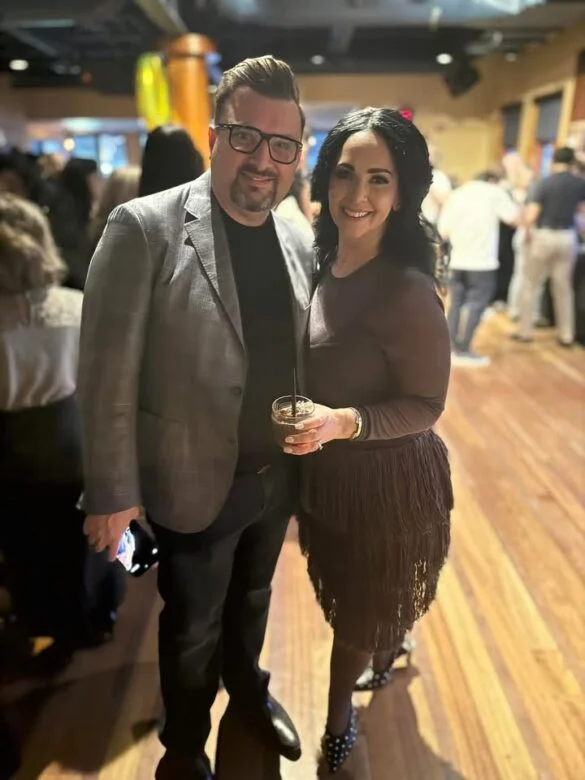 Couple posing for a photo indoors with a blurred background